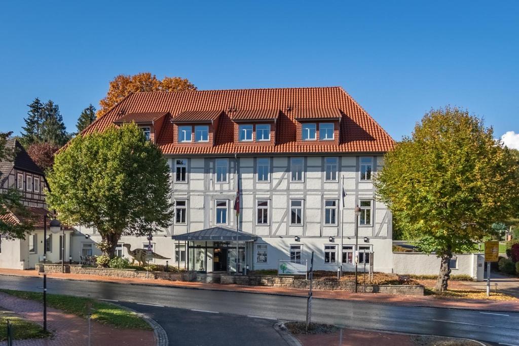 um grande edifício branco com um telhado vermelho em Parkhotel Bad Rehburg em Bad Rehburg