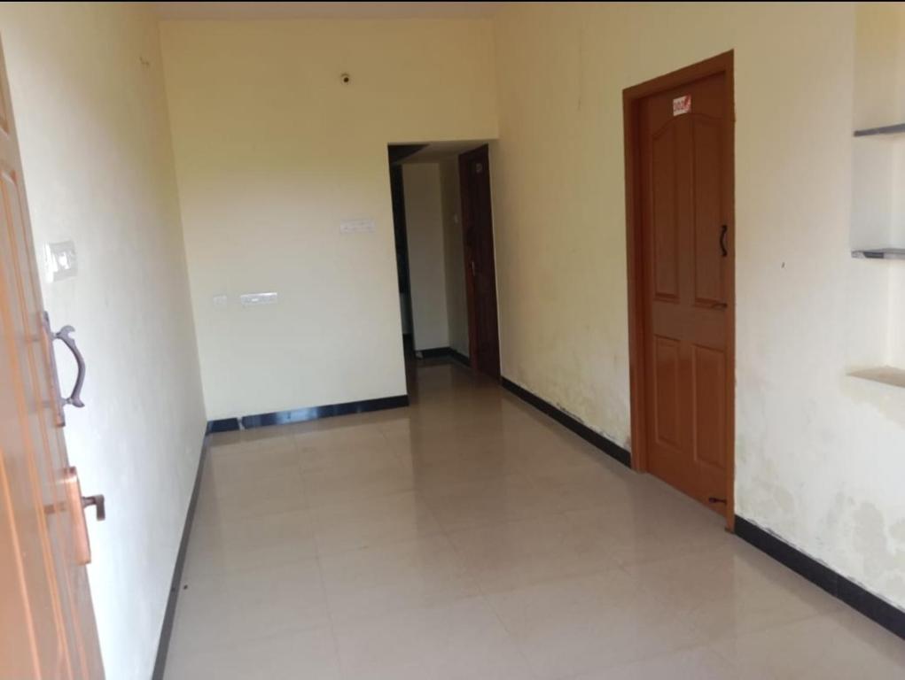 una habitación vacía con un pasillo con dos puertas en Tulips near SNS eng college, mullai hall, en Pīlamedu