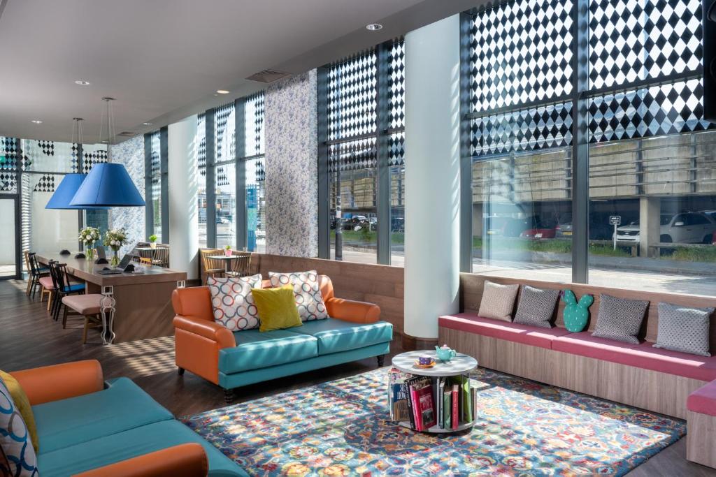 a lobby with couches and a table and windows at Leonardo Hotel Brighton in Brighton & Hove