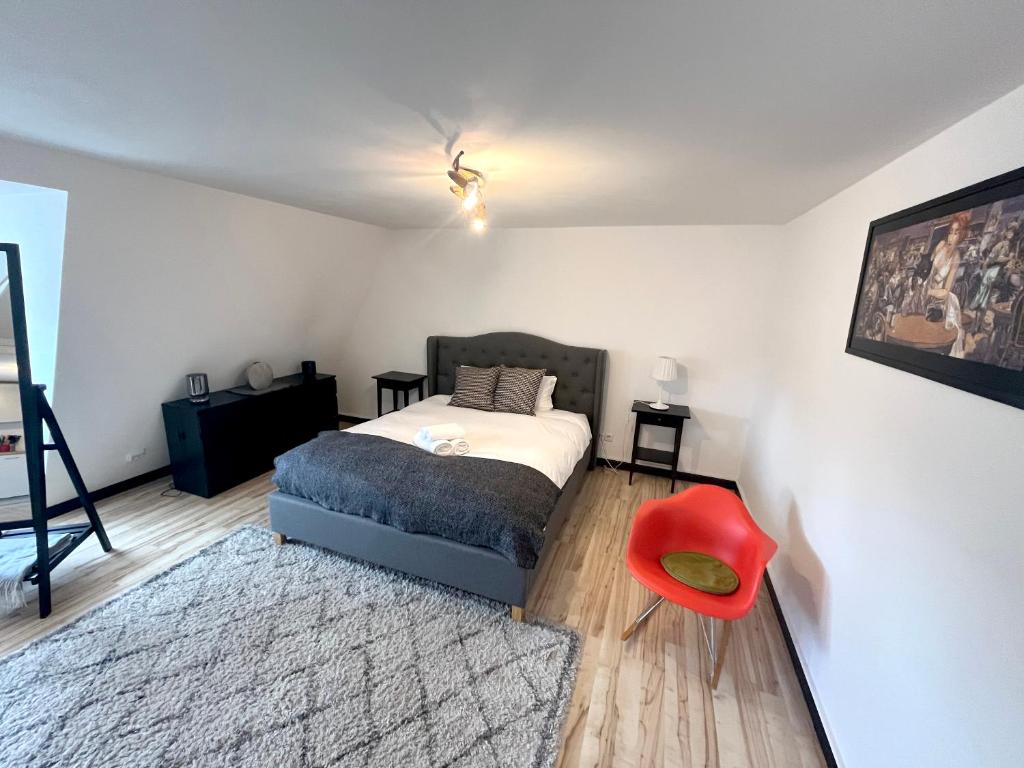 1 dormitorio con 1 cama y 1 silla roja en Jacob’s Barracks apartment in Old Town en Riga