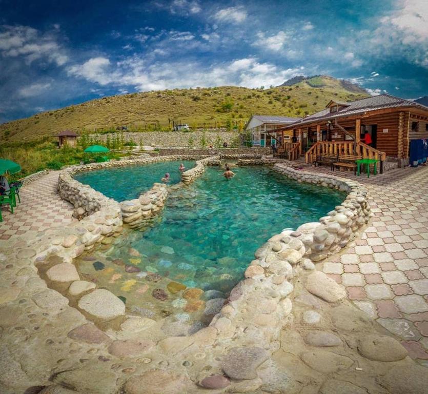 a swimming pool in front of a house at Royal Ak-Terek Issyk-kul in Ak-Terek