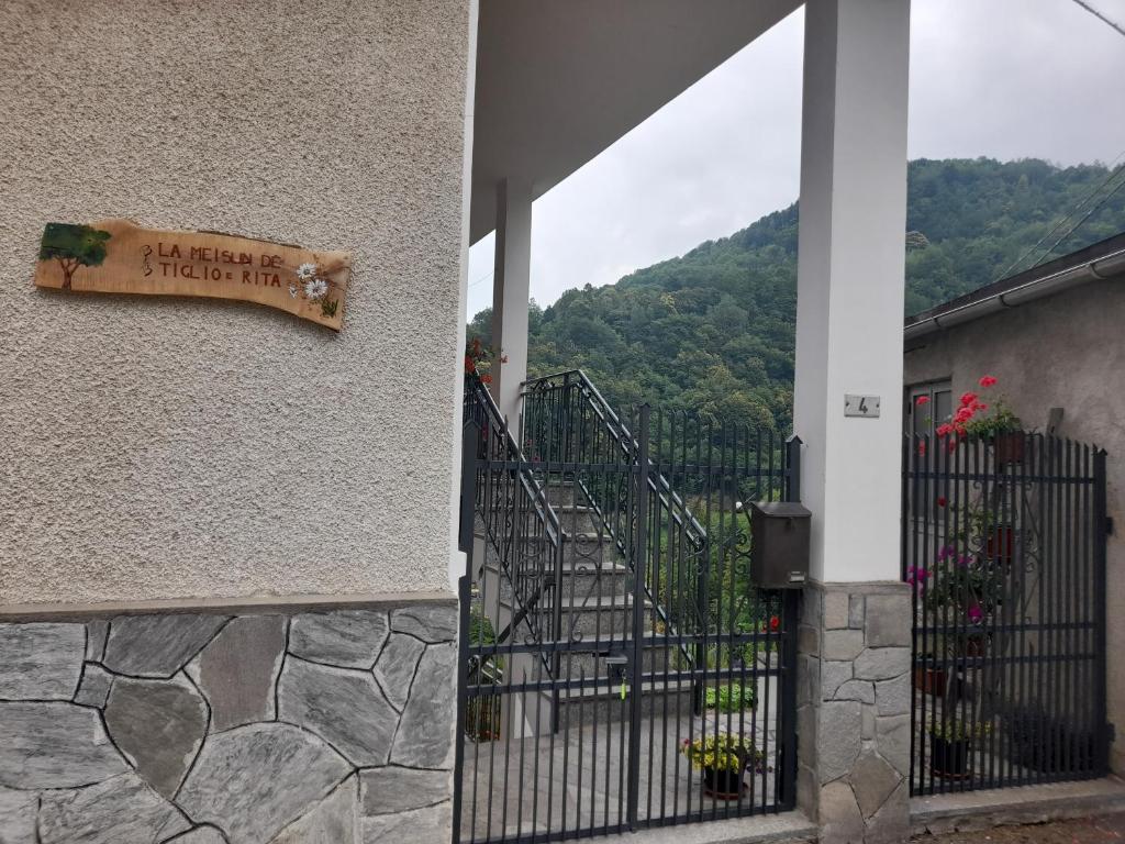 a sign on the side of a building with a gate at La Mëisun in Perrero