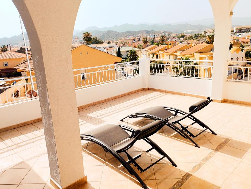balcón con sillas y vistas a la ciudad en ATICO ESTUPENDO, en Calabardina