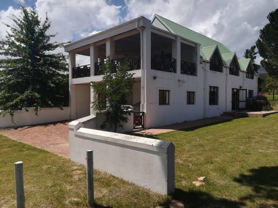 un gran edificio blanco con techo verde en The 10th Hole - Golf Estate, en Villiersdorp