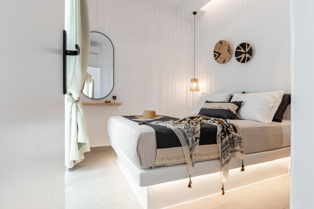 - une chambre blanche avec un lit et un miroir dans l'établissement Philisios Home 2, à Naxos Chora