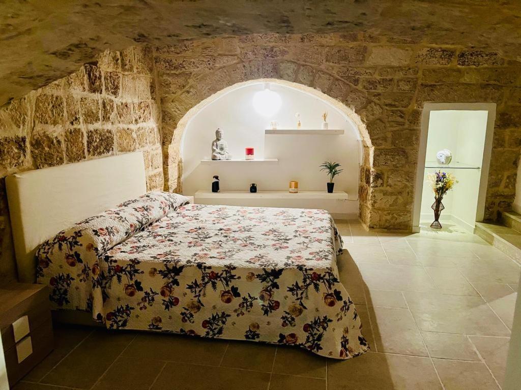 a bedroom with a bed in a stone wall at Le Mura di Gabry in Bari