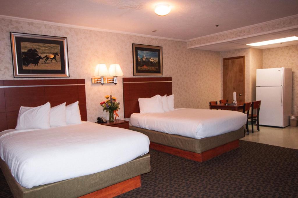 a hotel room with two beds and a refrigerator at Brandin' Iron Inn in West Yellowstone