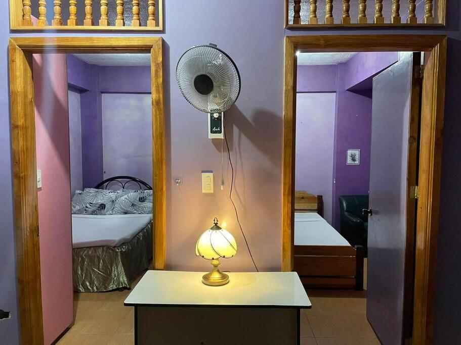 a room with a fan and a room with two beds at Budget Friendly Apartment 2rms in Baguio