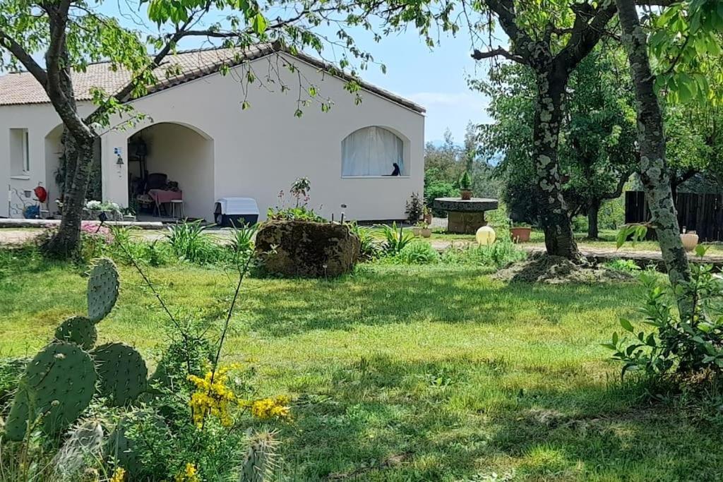 a white house with a yard with green grass and trees at Le Chausse à Brès Chambre d'hôtes 2 in Payzac