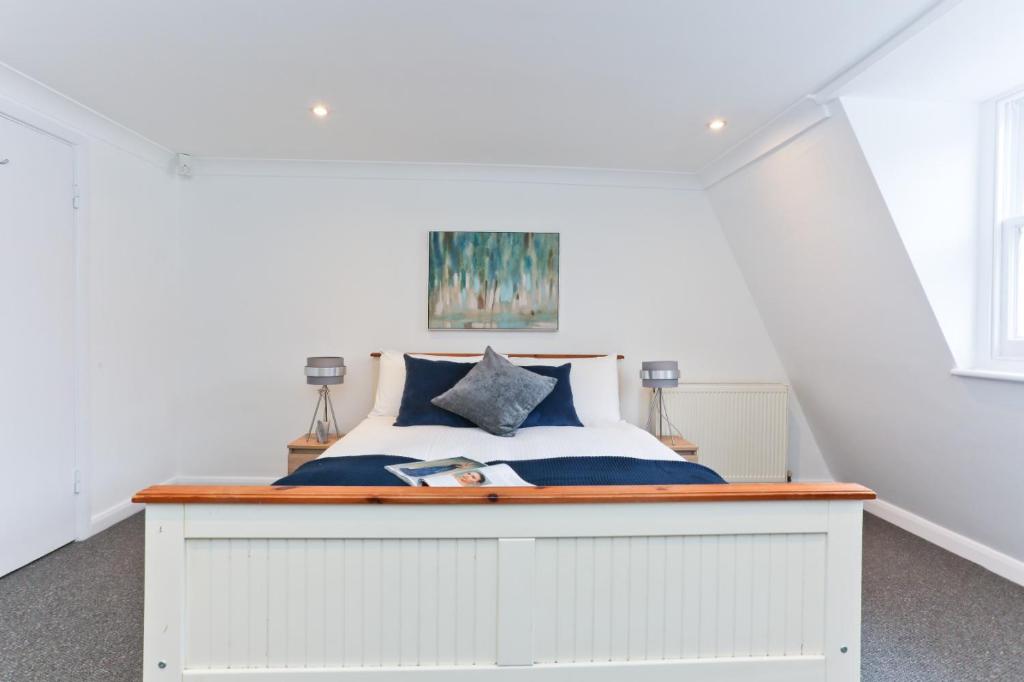 a bedroom with a white bed with blue pillows at Farringdon in London