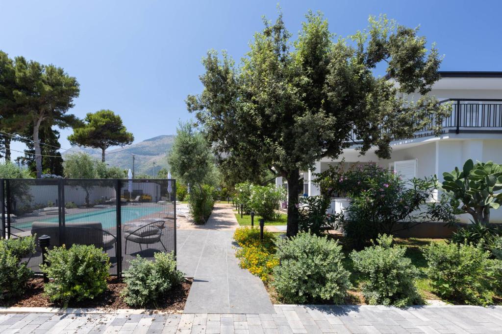 a garden with trees and a swimming pool at Sweet Sicily Apartments in Carini