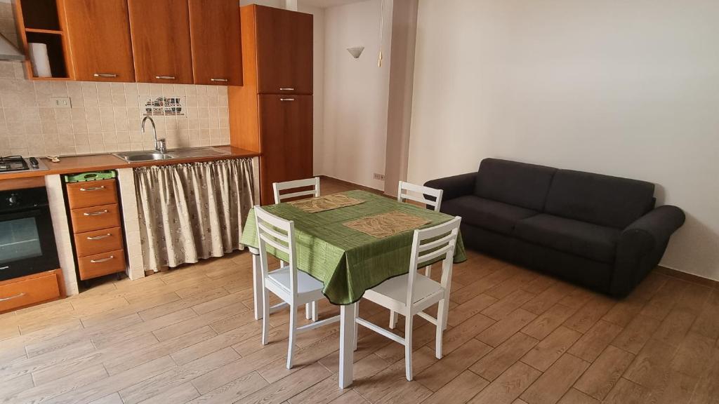 uma pequena cozinha com uma mesa e um sofá em La Casa di Trilly em Cerveteri
