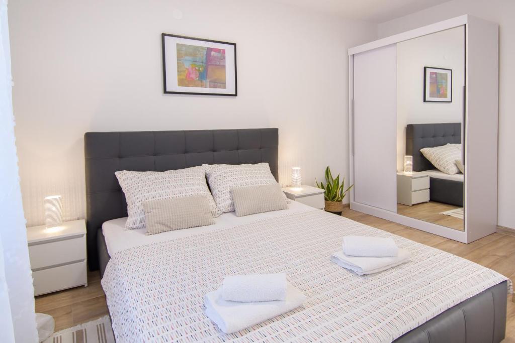 a bedroom with a large bed with two towels on it at Apartments & Rooms Darrer in Poreč