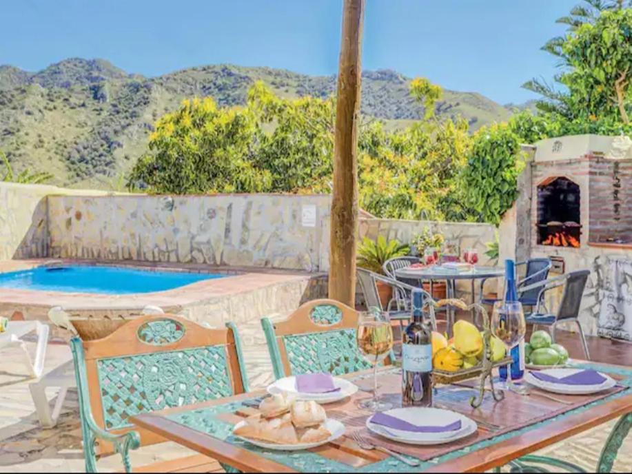 a table and chairs with a table and a pool at Villa Damara con piscina privada in Nerja