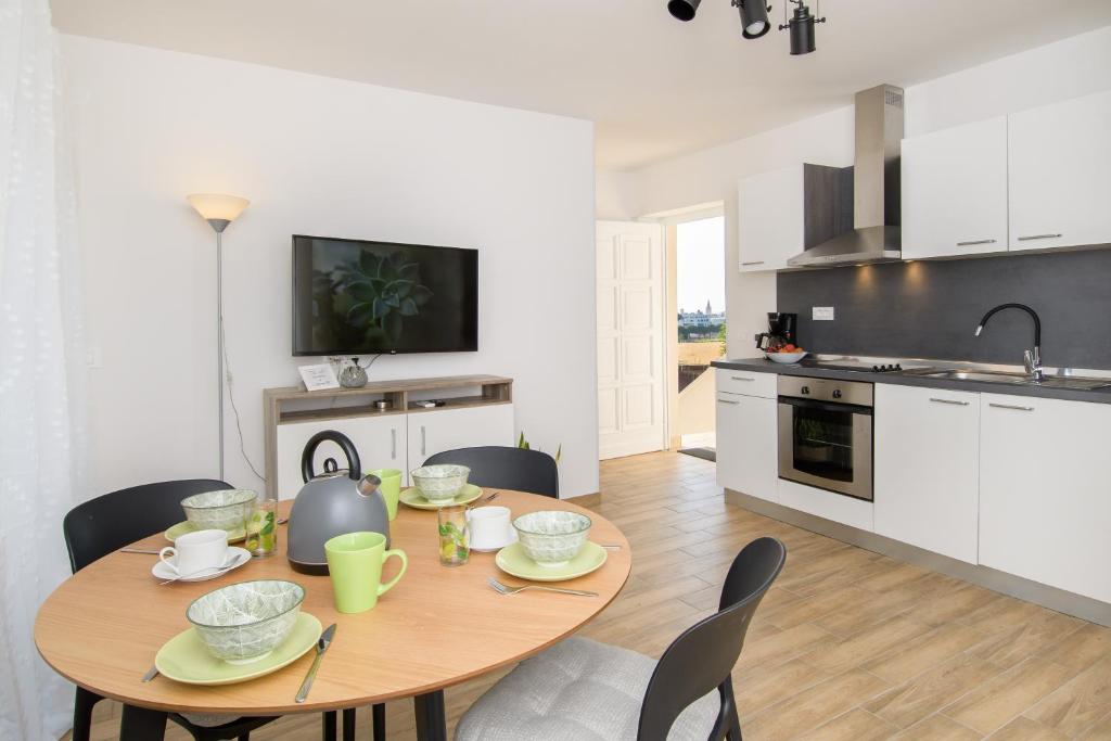 a kitchen and dining room with a table and chairs at Apartments & Rooms Darrer in Poreč