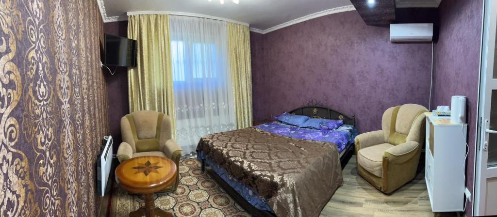 1 dormitorio con 1 cama y 2 sillas en Комната с собственной ванной комнатой, en Chişinău