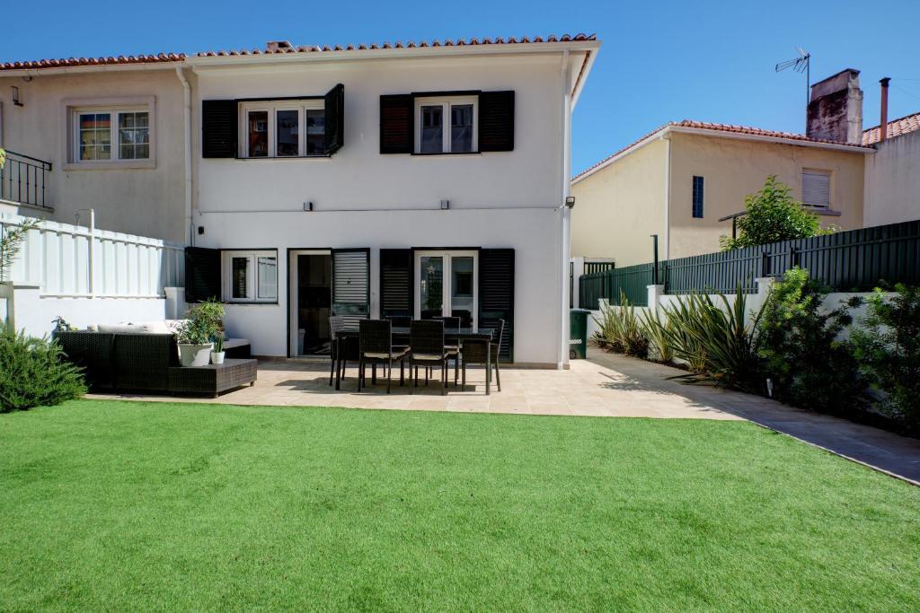 a house with a lawn in front of it at Comfortable Town House in Quiet Area by LovelyStay in Lisbon