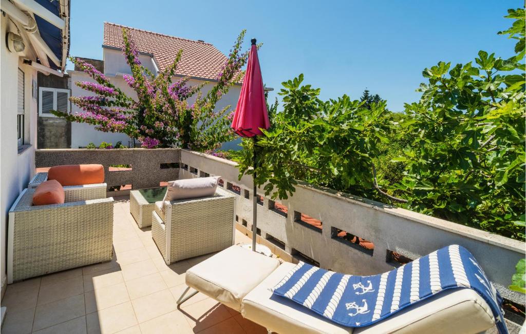 a patio with chairs and an umbrella on a balcony at Holiday Home Sucuraj 06 in Sućuraj