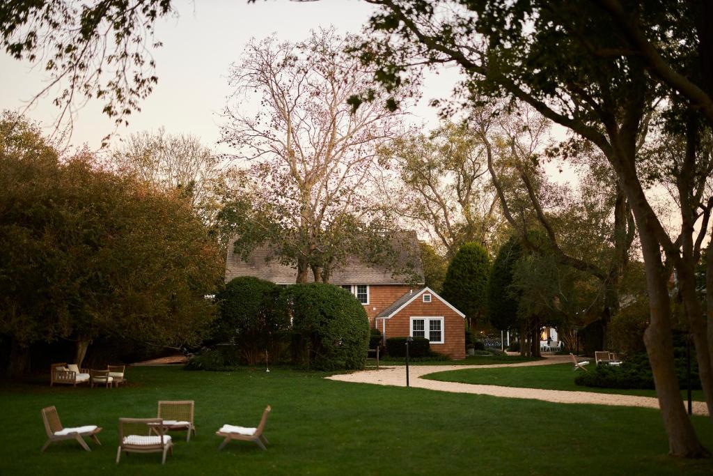 a park with benches and a house in the background at The Roundtree, Amagansett in Amagansett