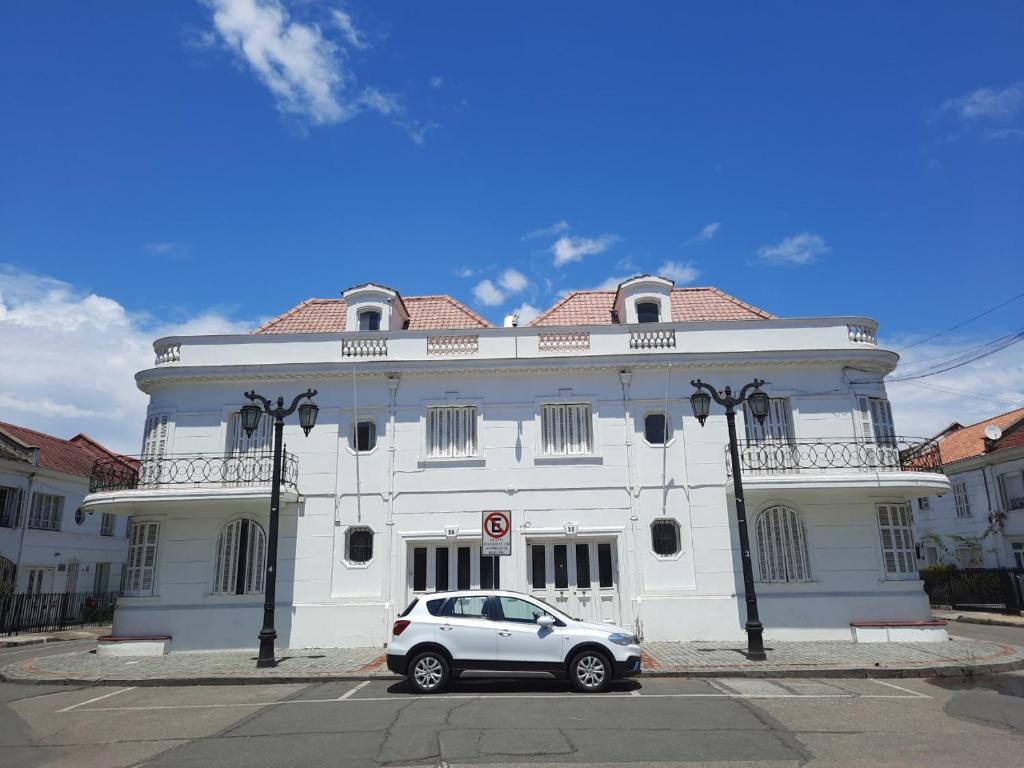 een wit gebouw met een auto ervoor geparkeerd bij RESIDENCIAL METRO REPUBLICA in Santiago