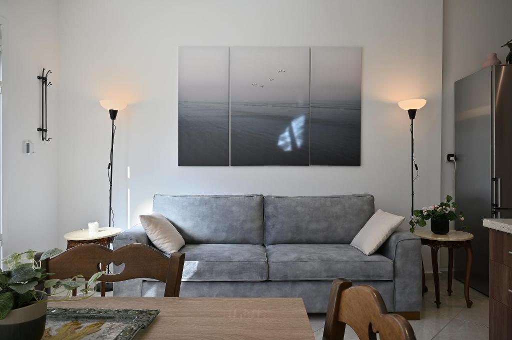 sala de estar con sofá y una foto en la pared en Seabreeze apartment in Palaio Faliro/ Netflix, en Atenas