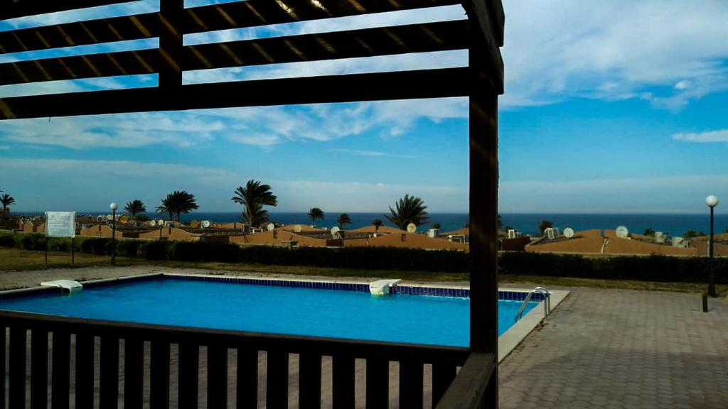 a swimming pool with a view of the ocean at Rania Chalet -Stella Di Mare Sea view- Families in Ain Sokhna