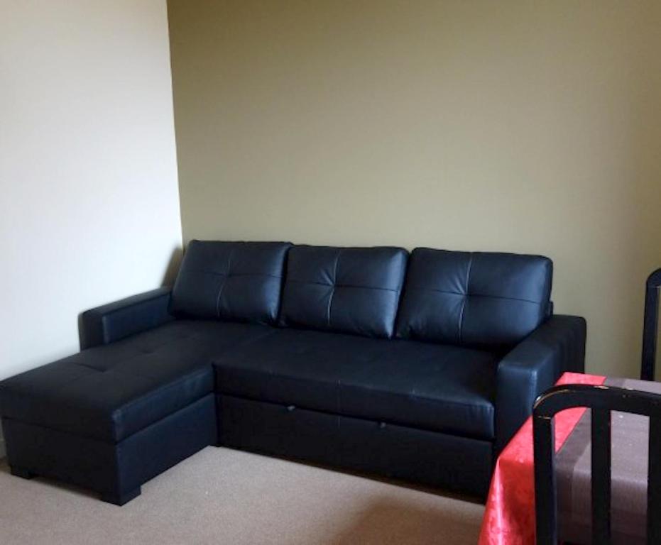 um sofá azul numa sala de estar com em Appartement d'une chambre avec jardin clos et wifi a Fauverney em Fauverney