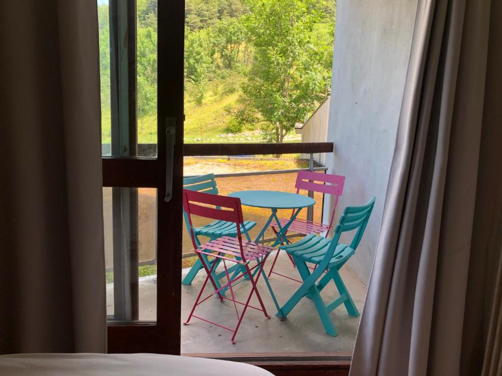 a table and chairs sitting on a balcony with a view at Studio au pied des sentiers in Villard-de-Lans