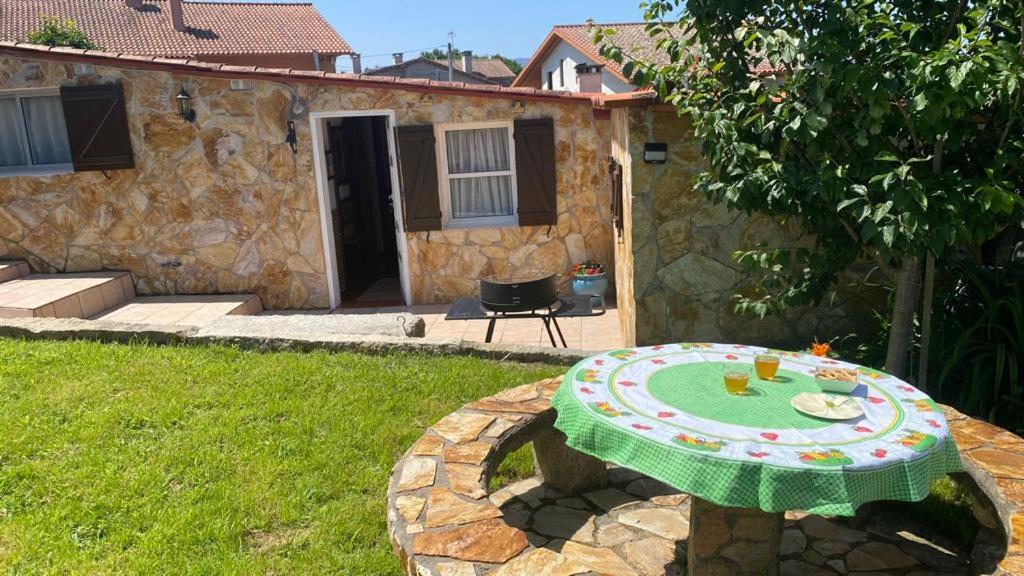 einen Tisch im Garten mit einem grünen Tisch in der Unterkunft Acogedora casa p/3 c/parking a 5 min de la playa in Nigrán