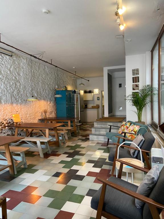 Amazigh Hostel & Suites في ألخيزور: غرفة معيشة مع طاولات وكراسي خشبية