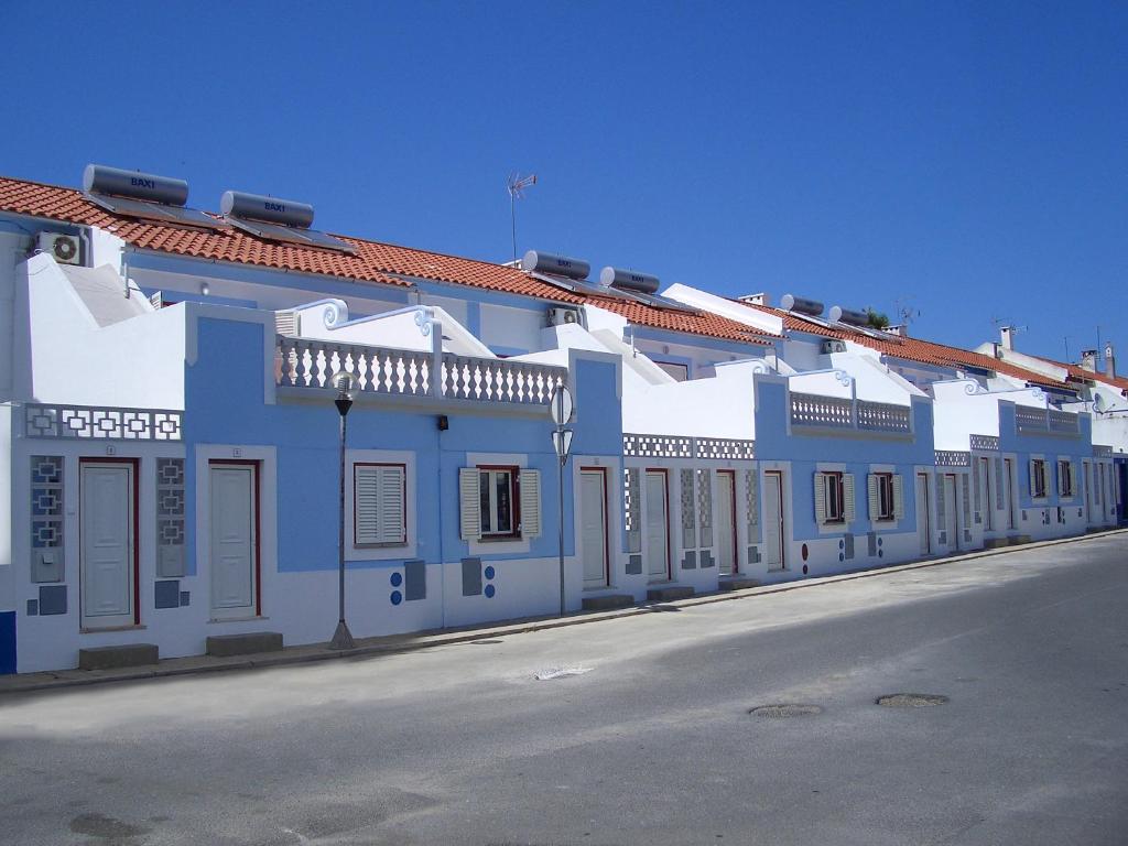 niebiesko-biały budynek po stronie ulicy w obiekcie Apartamentos Monte da Rosa w mieście Vila Nova de Milfontes