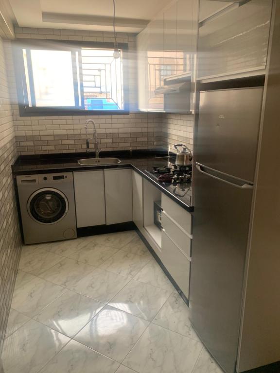 una cocina con frigorífico de acero inoxidable y lavavajillas en Appartement neuf bord de Mer à anza Agadir, en Agadir
