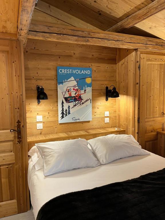 a bedroom with a bed in a wooden wall at Nid douillet au cœur de Megeve in Megève