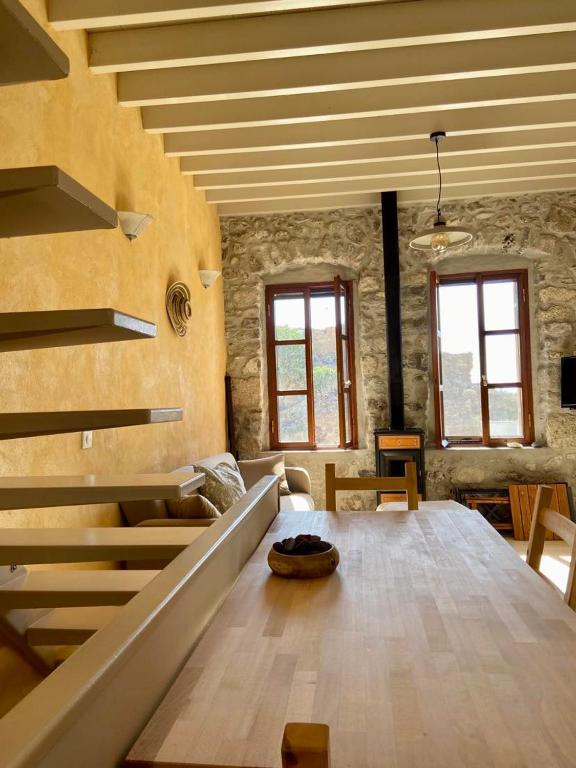 a living room with a wooden table and stairs at Monastery View House in Mandrakion
