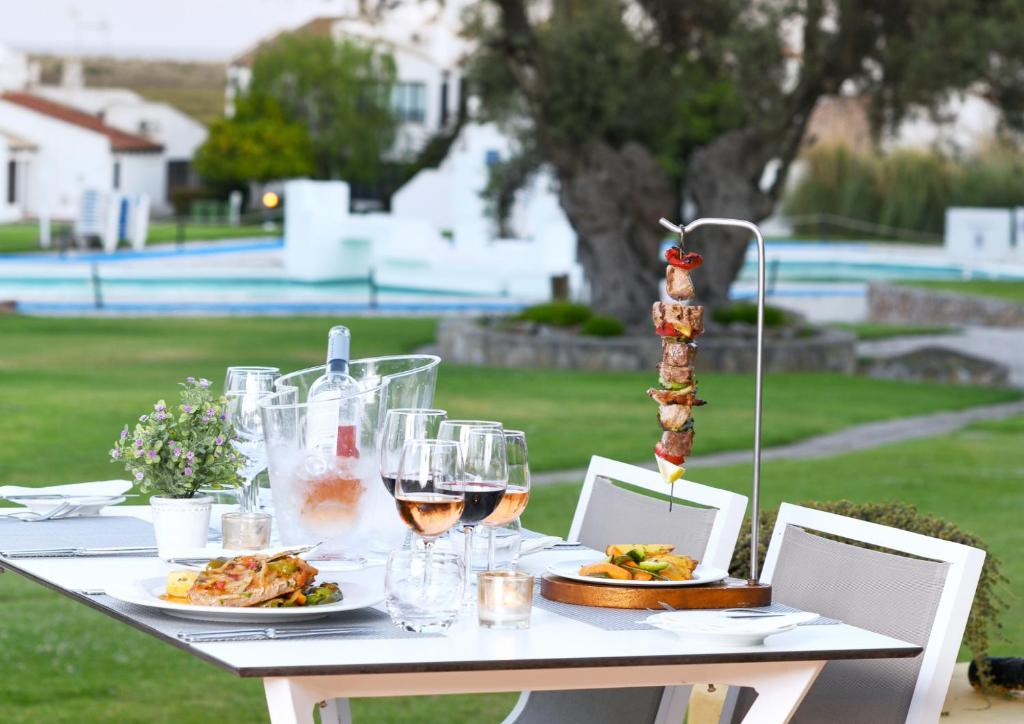 a table with plates of food and glasses of wine at Pedras D'el Rei in Tavira