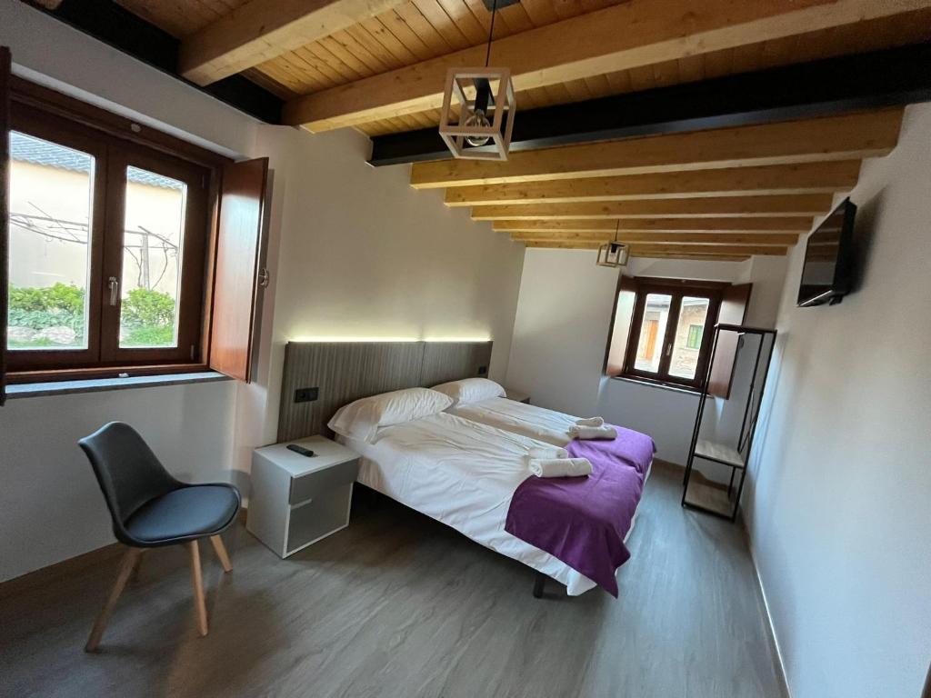 1 dormitorio con 1 cama y 1 silla en Casona de ventas, en Portomarín