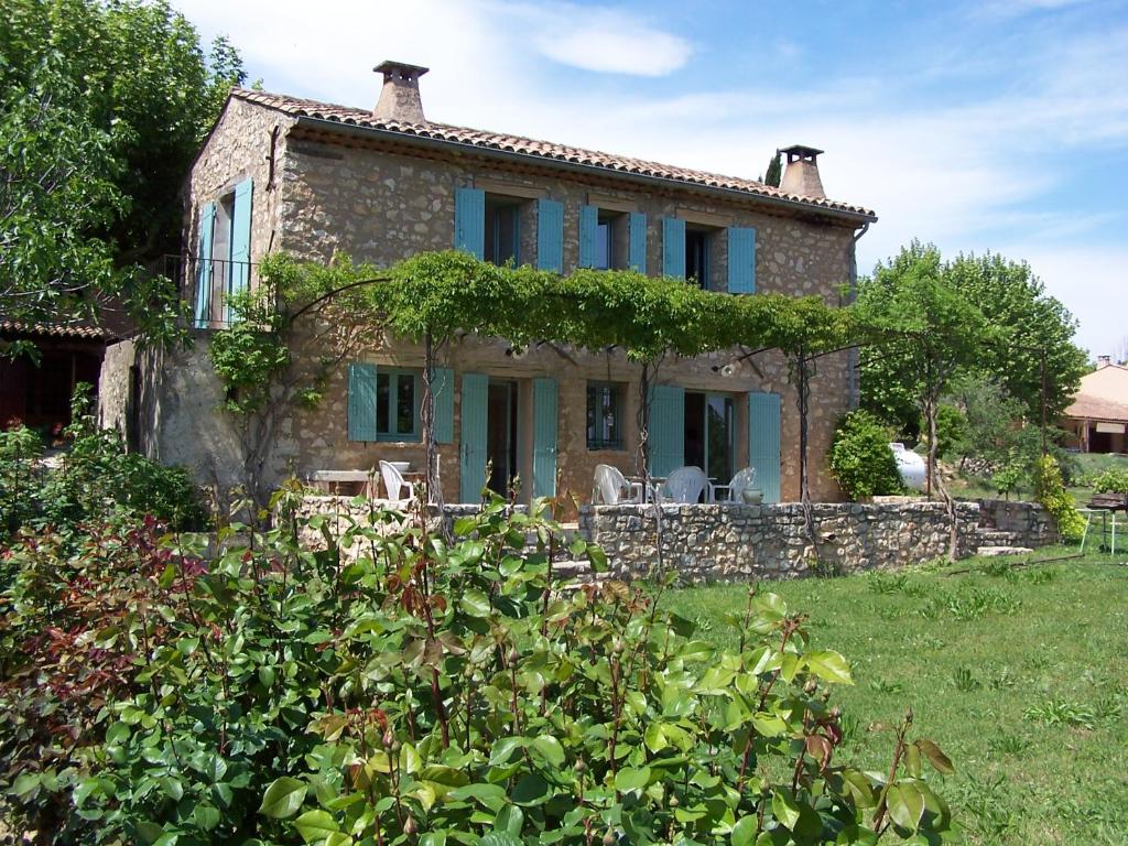 an old stone house with ivy growing on it at Les Vendangeurs, gîte au milieu des vignes face au Luberon in Goult