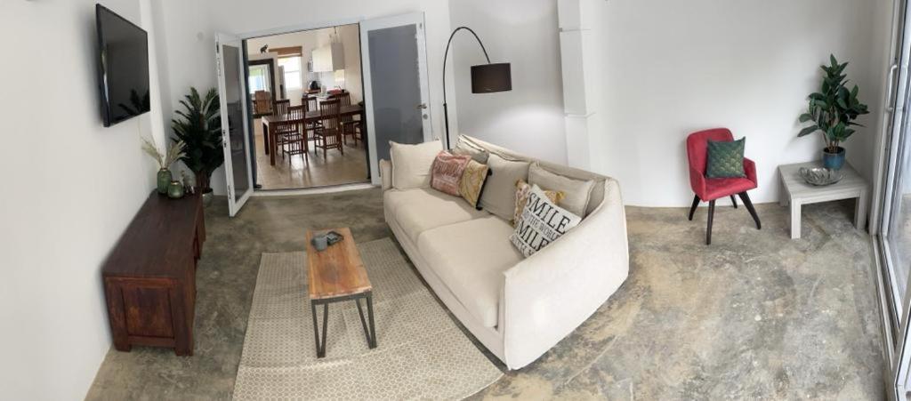 ein Wohnzimmer mit einer weißen Couch und einem roten Stuhl in der Unterkunft Villa Susanna 3 bedroom 2 bathroom house sleeps 6Plus in Willemstad