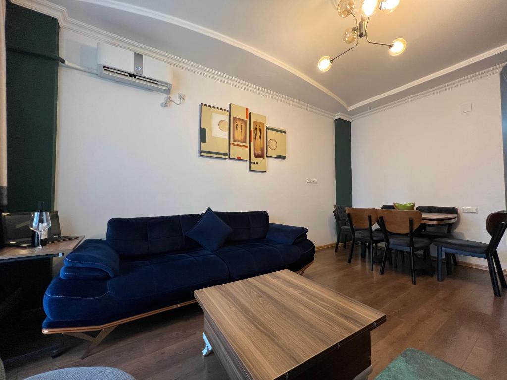 een woonkamer met een blauwe bank en een tafel bij Real Palace Apartments in Batoemi