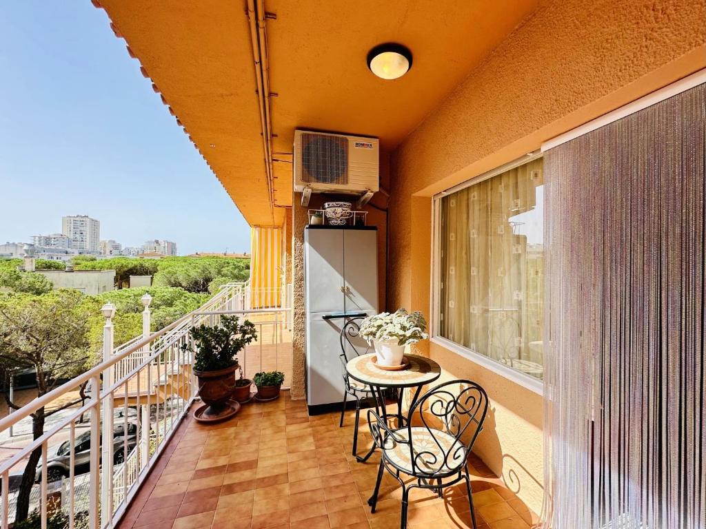 a balcony with a table and chairs and a television at Ambient CostaBravaSi in Platja d'Aro