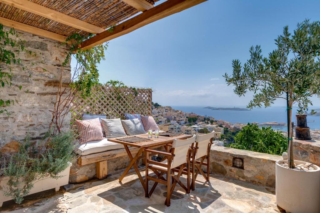 a patio with a table and chairs and a view at ALBA in Ermoupoli