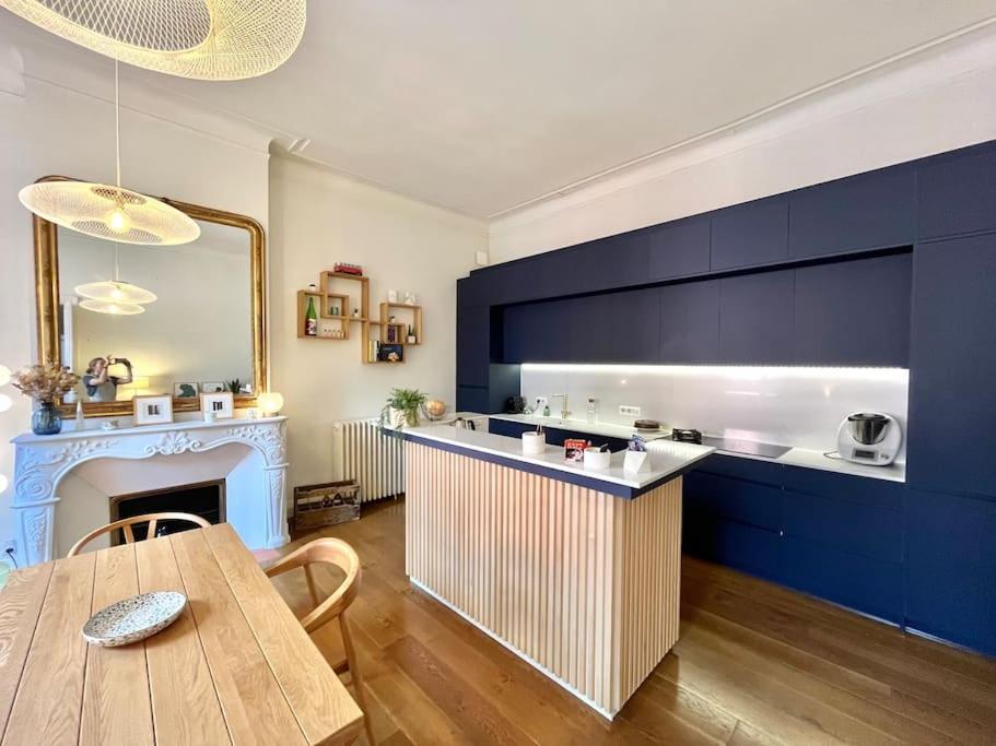 une cuisine avec une table et un mur bleu dans l'établissement Superbe duplex climatisé place St Etienne, parking, à Toulouse