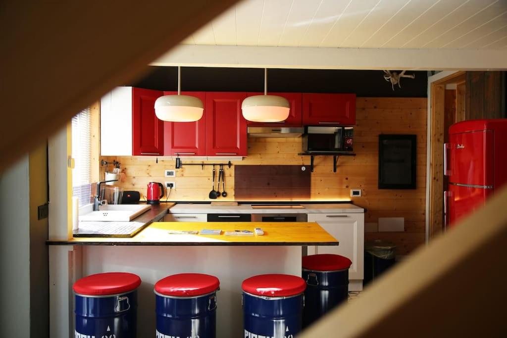 a kitchen with red cabinets and red stools at Piccu Go in Pisogne