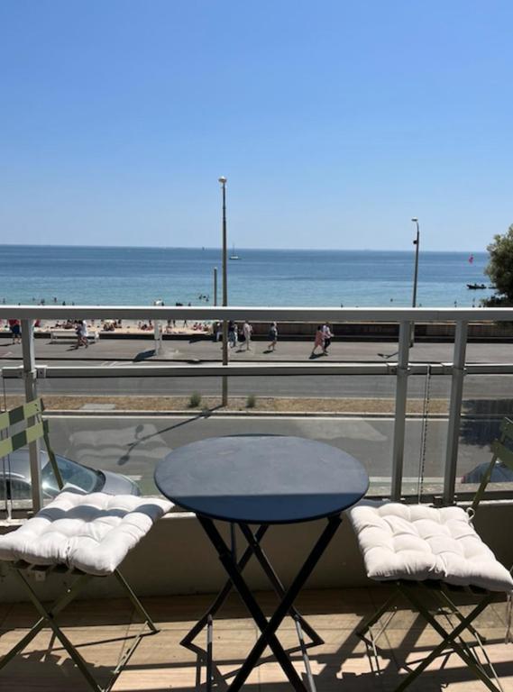d'une table et de chaises sur un balcon donnant sur la plage. dans l'établissement Studio And Terrace Sea View In La Baule, à La Baule