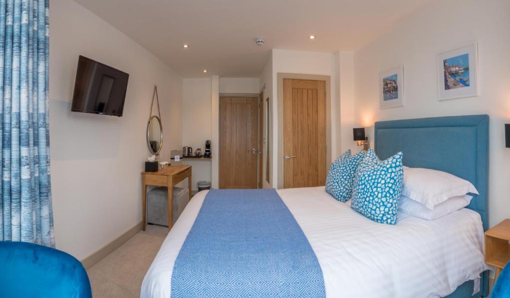 a bedroom with a blue and white bed and a television at Waterfront House in Dartmouth