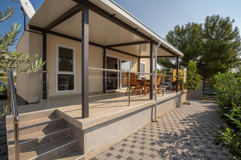 une maison dotée d'une terrasse couverte avec moustiquaire dans l'établissement Mobile House KASTANJOLA, à Biograd na Moru