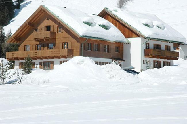 a house covered in snow with a pile of snow at Chalet Windegg in Sankt Anton am Arlberg