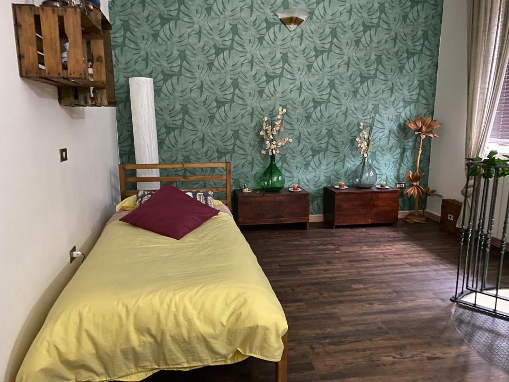 - une chambre avec un lit jaune et un mur vert dans l'établissement I TRE PORCELLINI, à Bagnoli Irpino