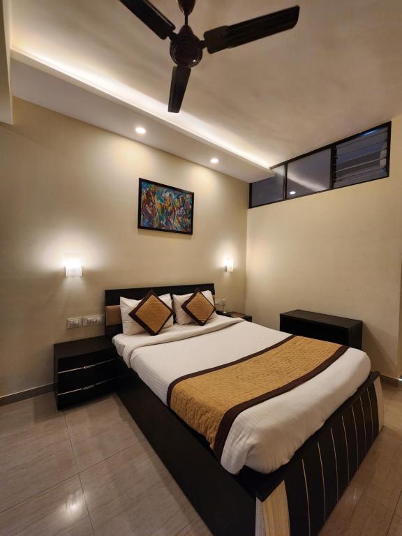 a bedroom with a large bed with a ceiling fan at All Seasons Guest House I Rooms & Dorms in Madgaon