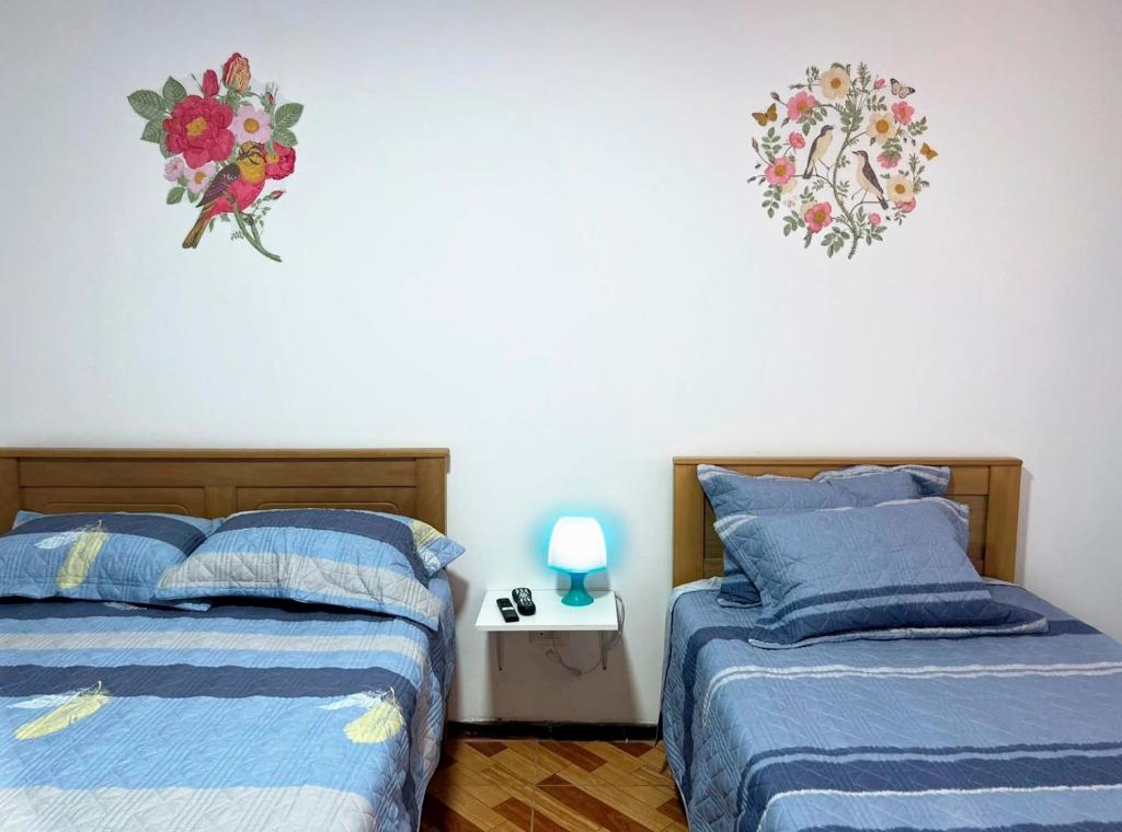1 dormitorio con 2 camas y mesa con lámpara en ACOGEDOR DEPA SAN MIGUEL, CON INTERNET, en Lima